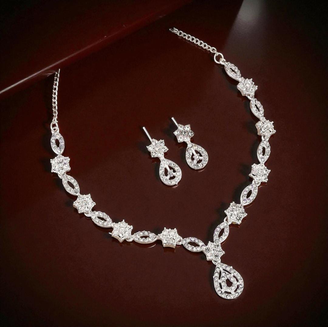 Elegant crystal and enamel leaf link necklace set with pearl drop.